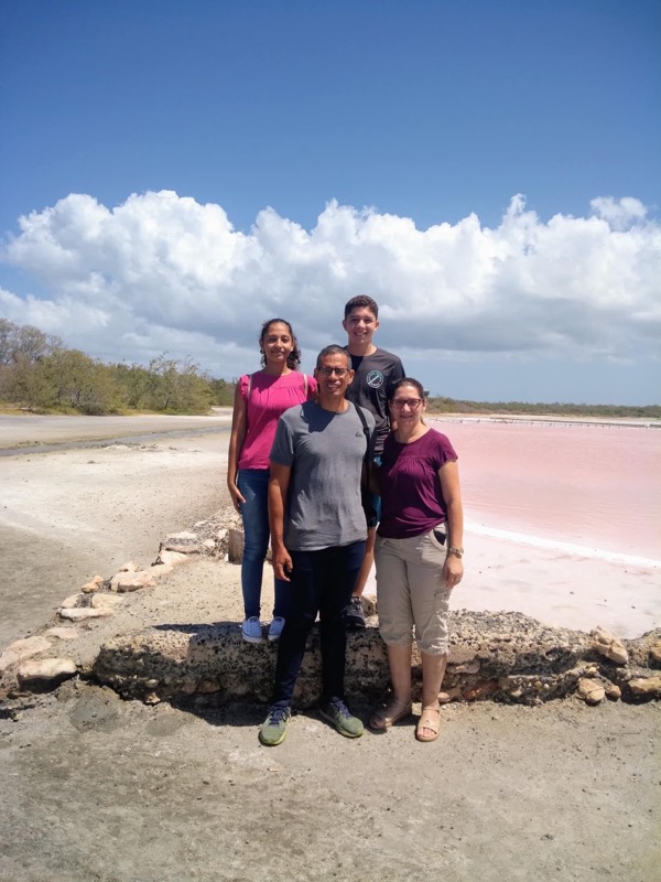 The author and his family in front of the pink water of a salt flat